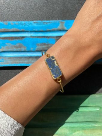 Bracciale in zama dorata, rigido, sottile. Chiuso, apribile con pietra. SUMO artigianato shop online Bigiotteria, Orecchini, Anelli, Bracciali, Collane. Argento 925, Pezzi Unici, Handmade, Arredamento Etnico, Accessori, Zaini e Borse, e tanto altro ancora. Scopri il mondo SUMO, vieni a visitare i nostri negozi a Bologna e Vignola a Modena.
