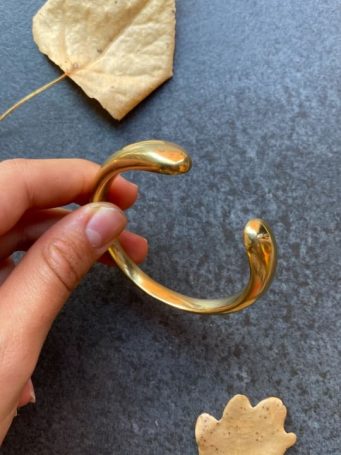 Bracciale rigido in ottone dorato a fascia pesante aperto diametro 5,5cm. Leggermente regolabile. SUMO artigianato shop online Bigiotteria, Orecchini, Anelli, Bracciali, Collane. Argento 925, Pezzi Unici, Handmade, Arredamento Etnico, Accessori, Zaini e Borse, e tanto altro ancora. Scopri il mondo SUMO, vieni a visitare i nostri negozi a Bologna e Vignola a Modena.